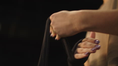 Unknown-woman-getting-ready-for-fight-at-gym.-Female-person-wrapping-hands