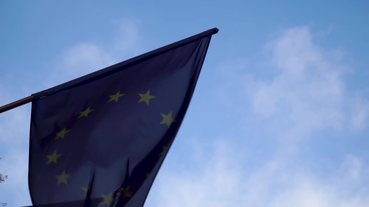 ondeando la bandera de la unión europea con el cielo azul en el fondo
