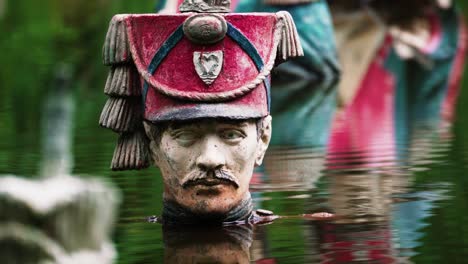 decaying soldier statue with moustache and napoleon era uniform in deep water