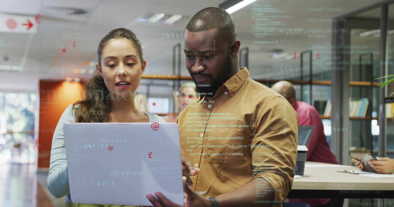 Woman holding laptop and man pointing at code, collaborating in tech library showing floating icons