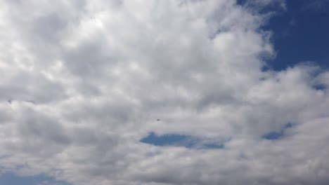 Extreme-wide-of-air-trike-flying-through-clouds-from-beach-on-a-fine-day