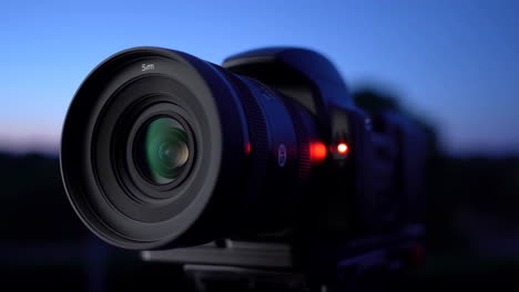 close-up of a camera lens against a twilight sky