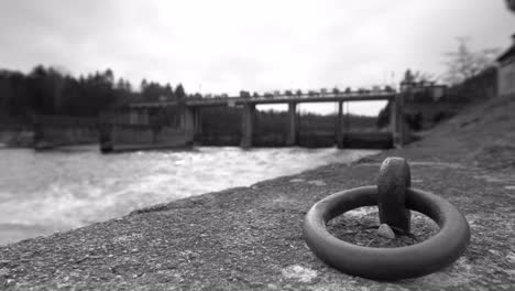 Agua-Que-Fluye-Procedente-De-Un-Vertedero-Con-Cambio-De-Enfoque-En-Blanco-Y-Negro-Desde-Una-Perspectiva-Más-Baja-En-El-Sur-De-Baviera