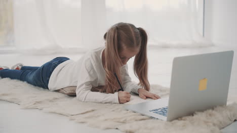 Niña-Pequeña-Haciendo-La-Tarea-Usando-La-Computadora-Portátil-En-Casa