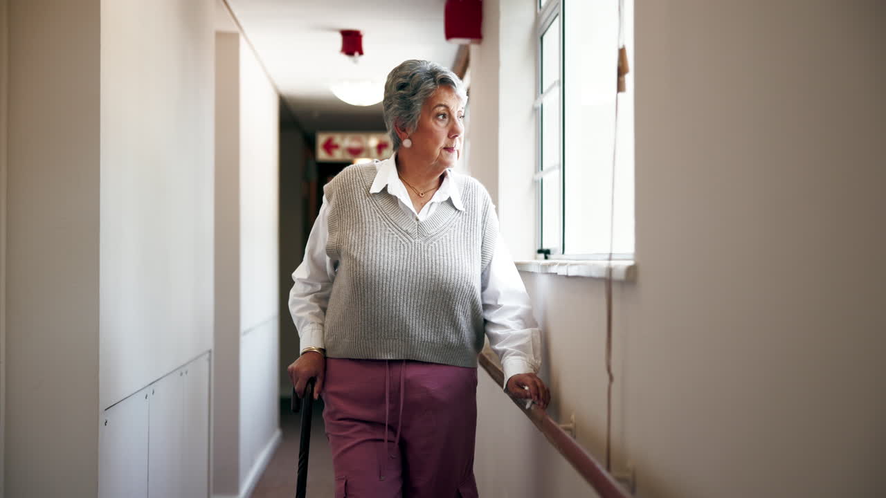 Senior woman with cane in hallway of assisted living facility