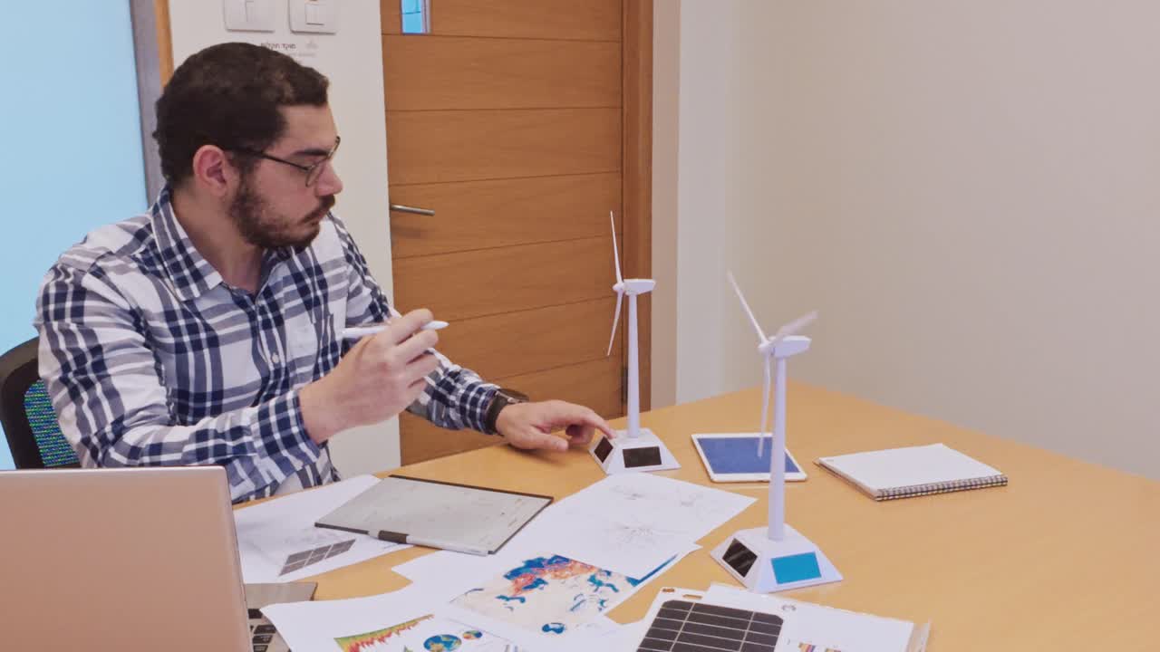 Male Architect Sketching a Wind Turbine Design by Hand