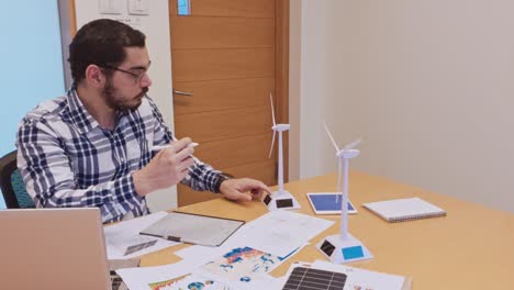 male architect sketching a wind turbine design by hand