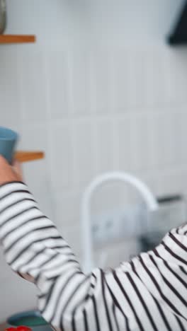 mujer bebiendo café en la cocina