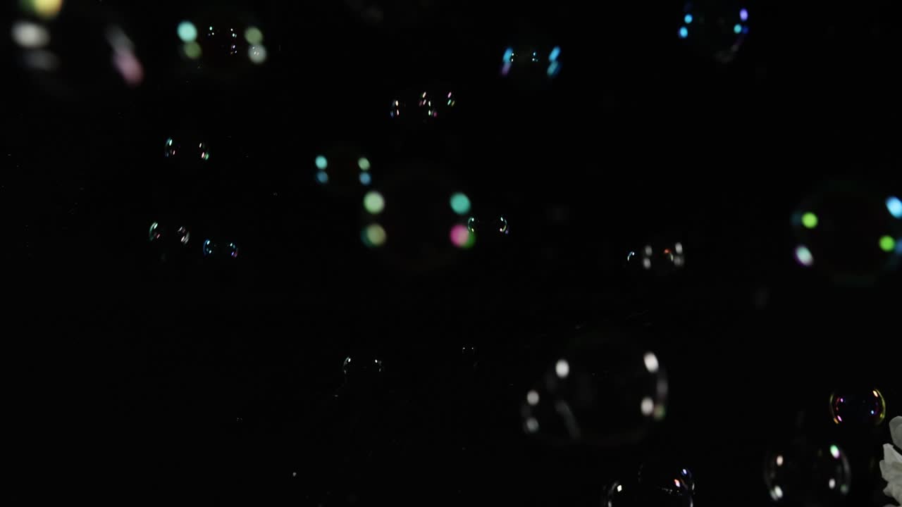 어두운 공간에서 떠다니는 다채로운 비누 거품