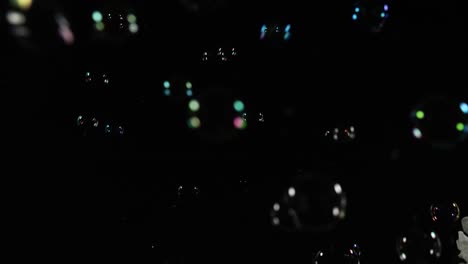 burbujas de jabón coloridas flotando en un espacio oscuro