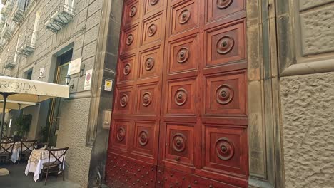 large wooden door beside outdoor cafe seating