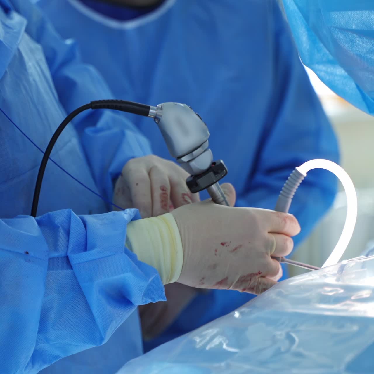 Medical instruments in doctor's hands during operation. Surgical procedure by specialist in medical gloves. Saving life concept