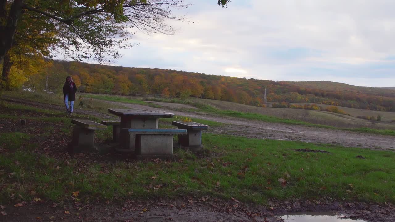 mujer caminando sola en la colina en cluj-napoca, rumania - bosque de hoia en otoño - toma amplia