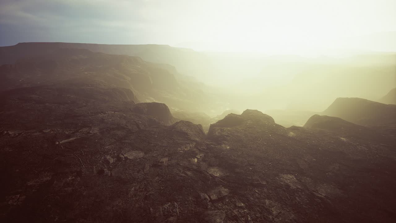Majestic volcanic landscape shrouded in ethereal mist at dawn