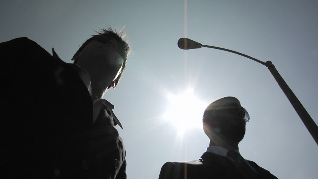 한 남자가 교활하게 다른 남자에게 봉투를 전달합니다.