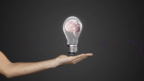 Animation-of-human-brain-in-light-bulb-on-cropped-hand-of-caucasian-woman-against-black-background