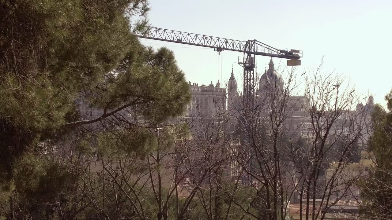 grúa de construcción de madrid en el trabajo y el palacio real visto desde el parque de debod