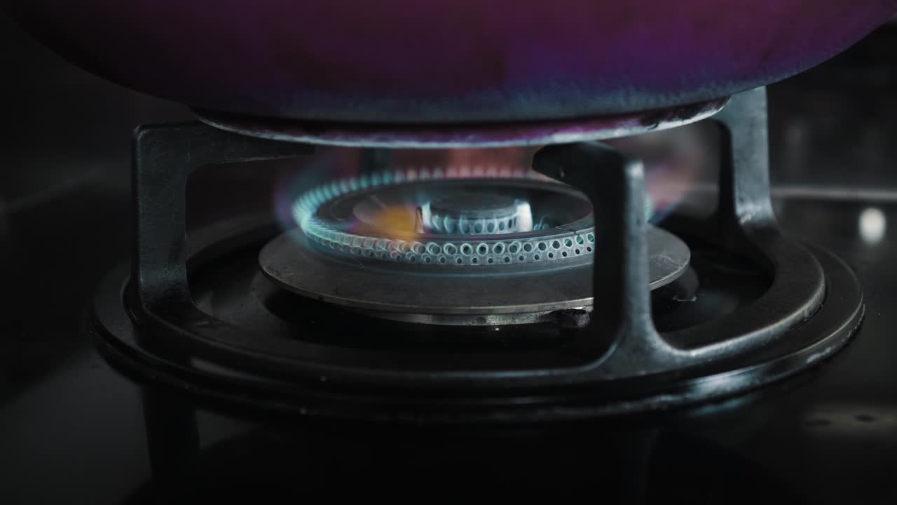 부에서 파란색과 빨간색으로 불타는 불꽃이 있는 검은색 가스 스토브의 비디오