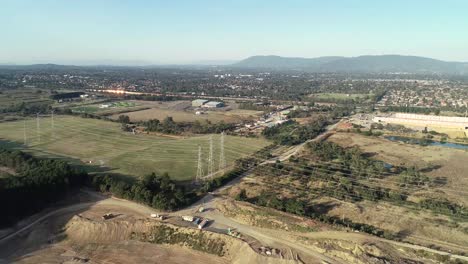 smooth orbital pan to the left showing quarry below as green nature band moves along between suburban regions.