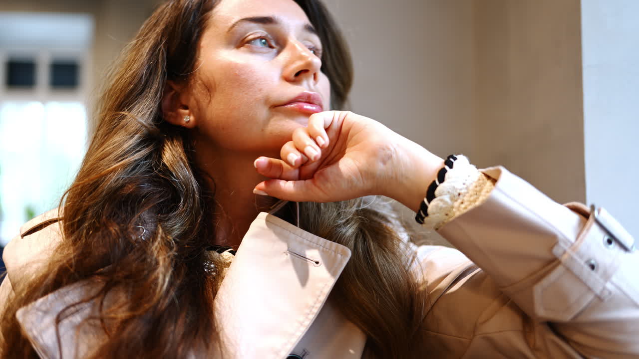 Pensive woman looking through the window in a cafe