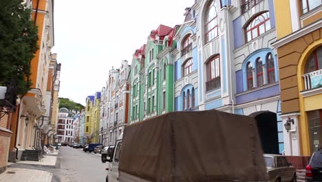 A-truck-drives-down-a-road-filled-with-colorful-buildings-in-Ukraine