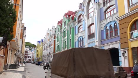 a truck drives down a road filled with colorful buildings in ukraine