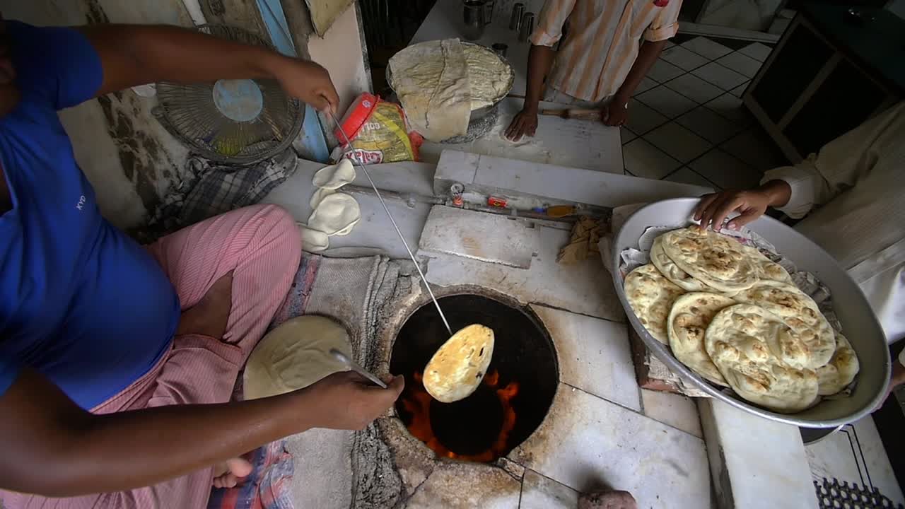 hombre cocinando comida callejera india