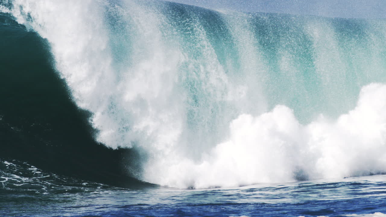 Towering wave collapses in a spray explosion with glowing mist and sharp texture