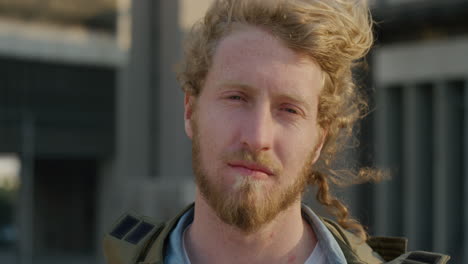 retrato joven hombre caucásico gira la cabeza buscando un hombre serio e independiente disfrutando de un estilo de vida relajado en la ciudad al atardecer el viento sopla el cabello serie de personas reales