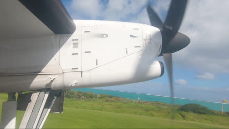 ventana de avión pov que muestra la hélice y la pista lord howe island australia con el tren de aterrizaje retráctil