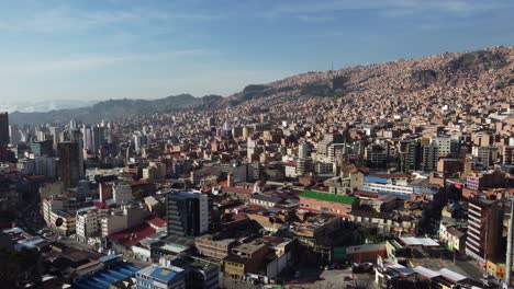 Cable-cars-glide-above-as-aerial-rises-over-skyline-of-Oruro,-Bolivia