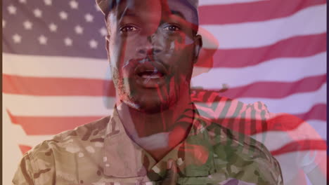 soldier placing hand over heart during tech briefing, showing camouflage uniform with animated flag