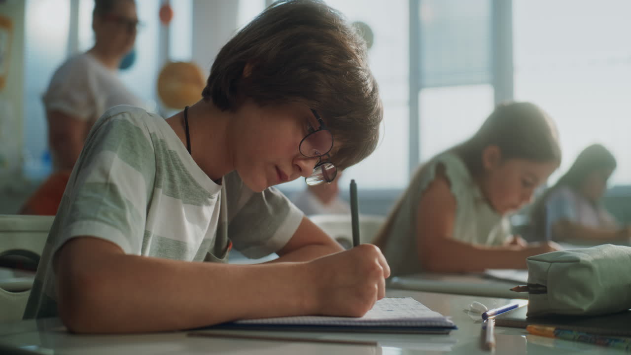 Primary School Boy Writing School Test Doing Task in Notebook