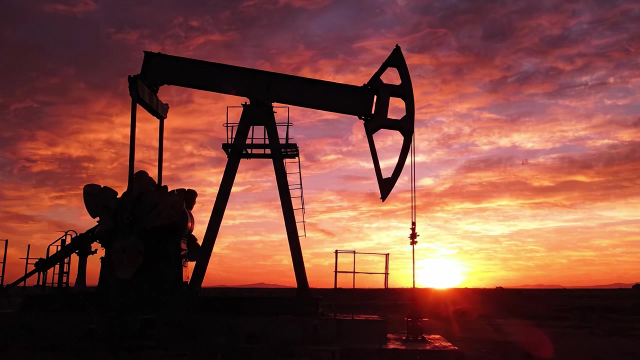 A Stunning Sunset Over Oil Pumps, Capturing the Industrial Landscape in Silhouette Against Vibrant Skies, Demonstrating the Interplay Between Nature and Energy Production.