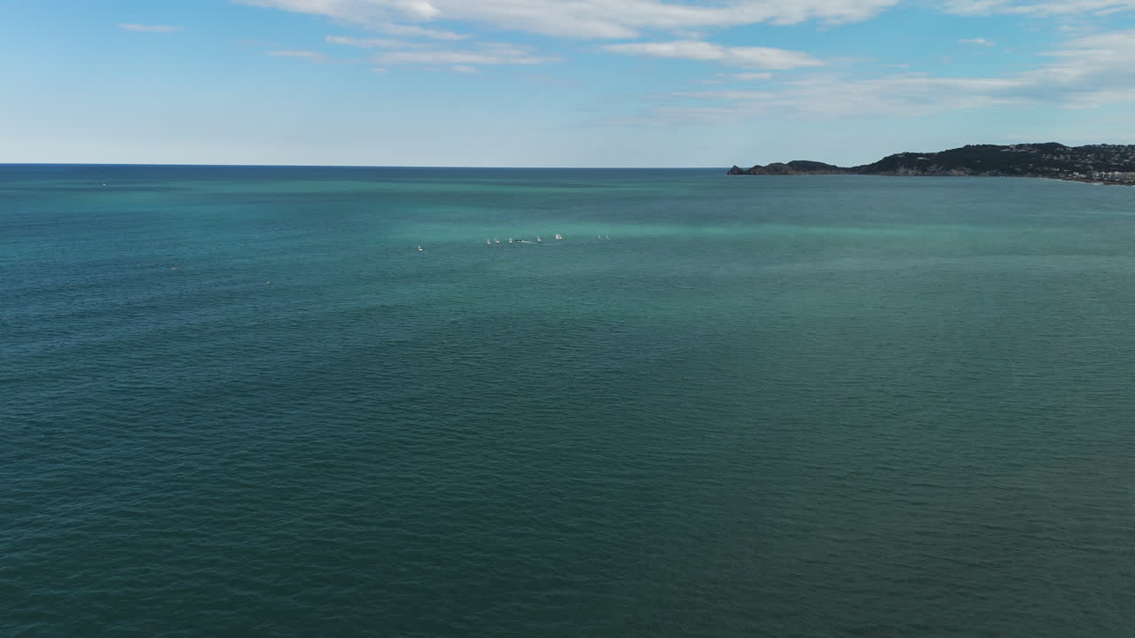 Open blue ocean fades into hazy horizon under calm sky off Xabia's coastal line