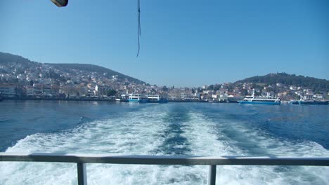 Blick-Von-Der-Rückseite-Eines-Bootes,-Das-Langsam-Den-Hafen-Auf-Einer-Insel-Vor-Der-Küste-Der-Türkei-Verlässt