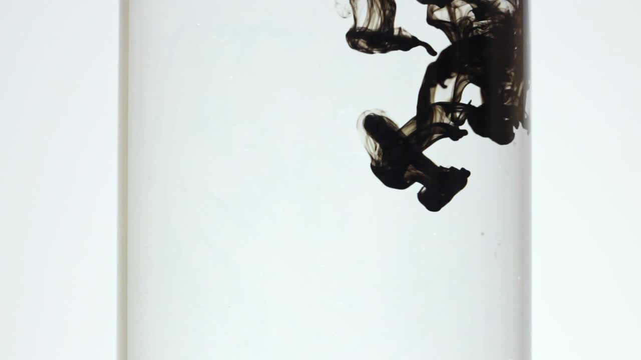 慢速移動的黑色墨水擴散到透明的水中