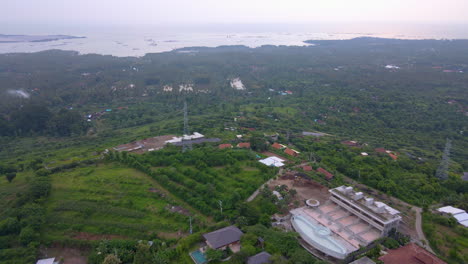 Luftaufnahme-Der-Resort-Villa-Mit-Swimmingpools,-Umgeben-Von-üppigem-Grün-An-Der-Küste-Von-Bali,-Indonesien