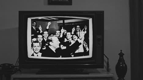 a vintage black-and-white video on a retro tv shows a group of people smiling