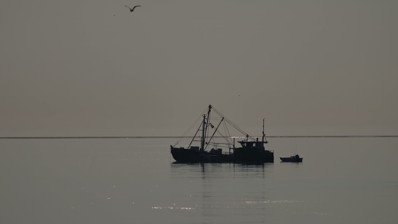 Fishing boat silhouette at dawn/dusk