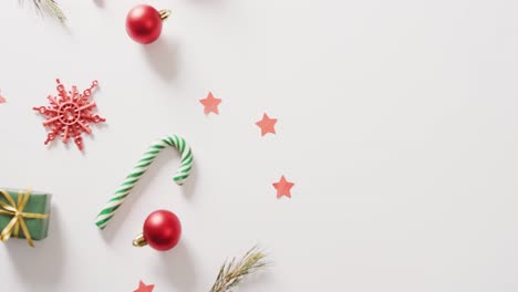 video of two christmas canes and decorations over white background