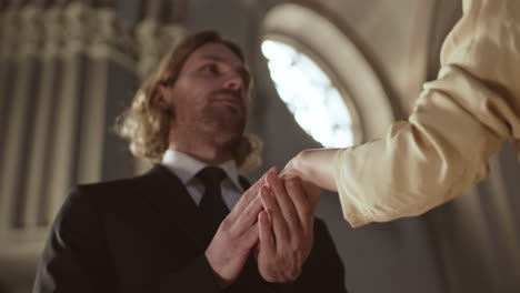 groom putting ring on bride during wedding ceremony