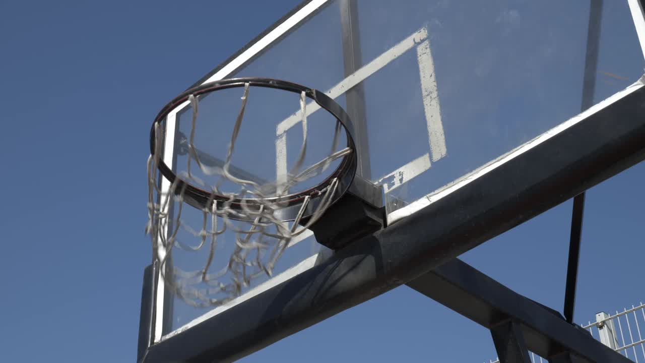 triunfante lanzamiento de la victoria en una cancha de baloncesto soleada en cámara lenta