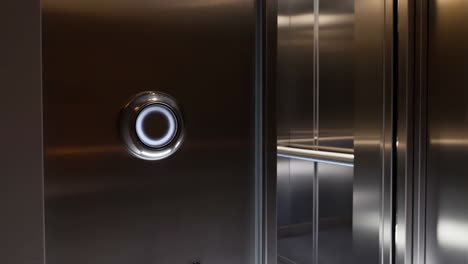 illuminated elevator call button and open doors