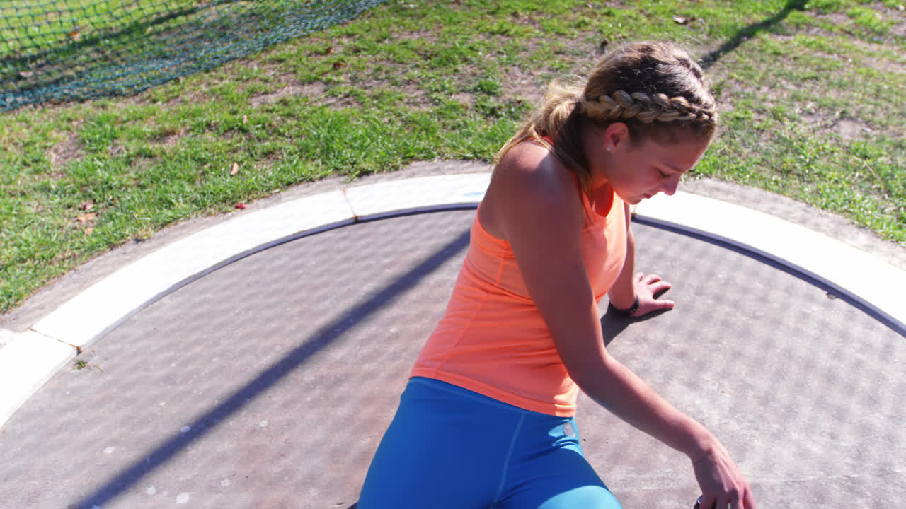 vista frontal de una atleta caucásica usando un teléfono móvil en un recinto deportivo 4k