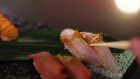 una persona probando sushi de un plato