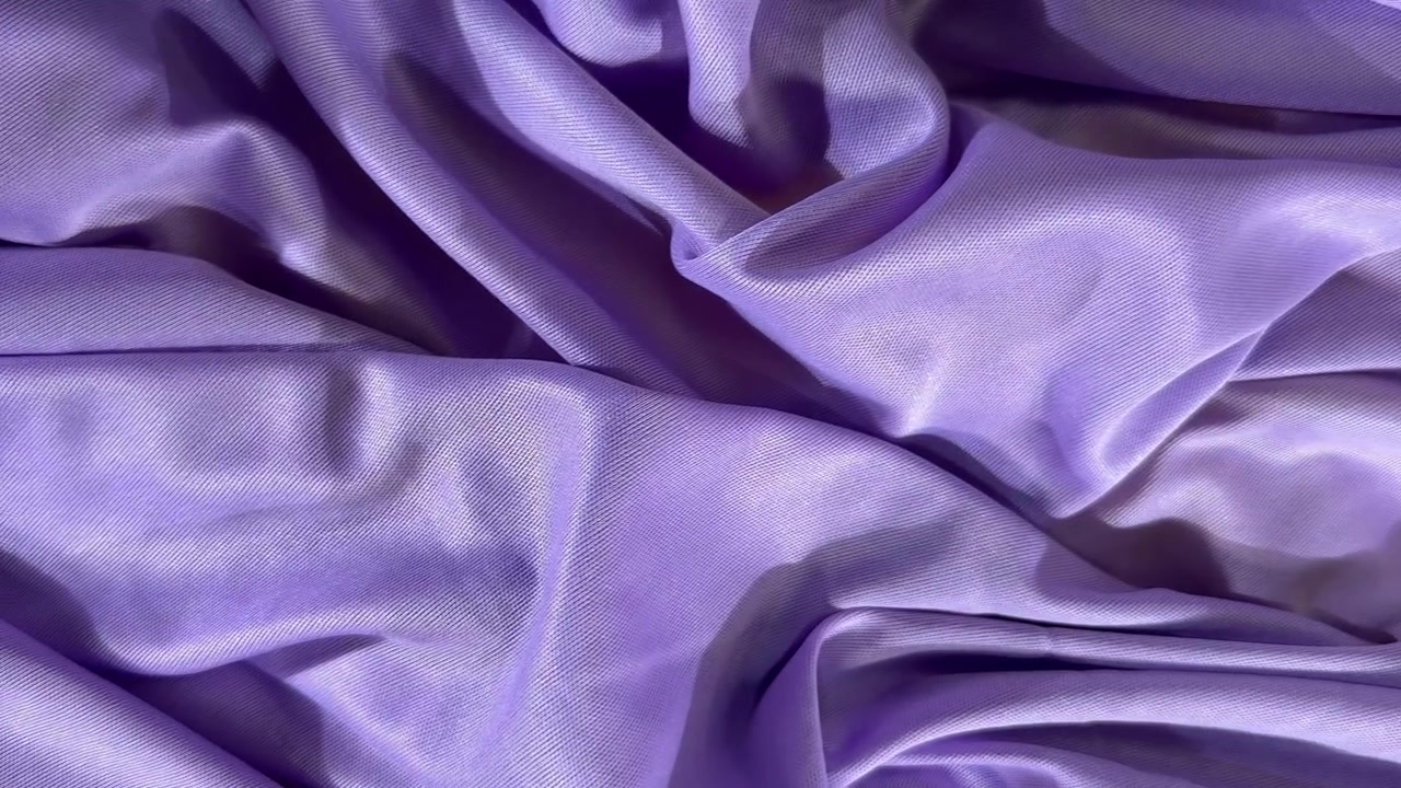 Tessuto di raso viola morbido che si drappeggia e si muove.