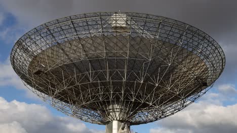 satellite dish rotates slowly under changing skies