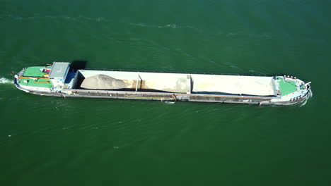 barge carrying sand and gravel on a river