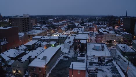 Establishing-shot-of-urban-city-in-USA-covered-in-winter-snow-at-night